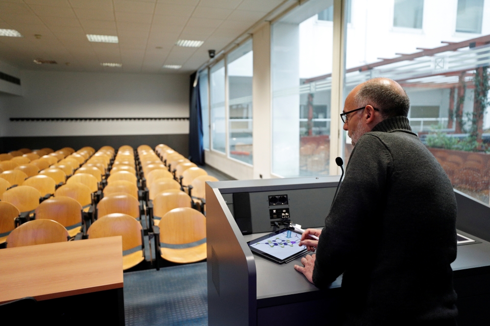 University chemistry professor Luca De Gioia uses his tablet to record his lesson in an empty class room to stream it online for his students at the Bicocca University in Milan, Italy, March 2, 2020.  Reuters/Guglielmo Mangiapane
 
 