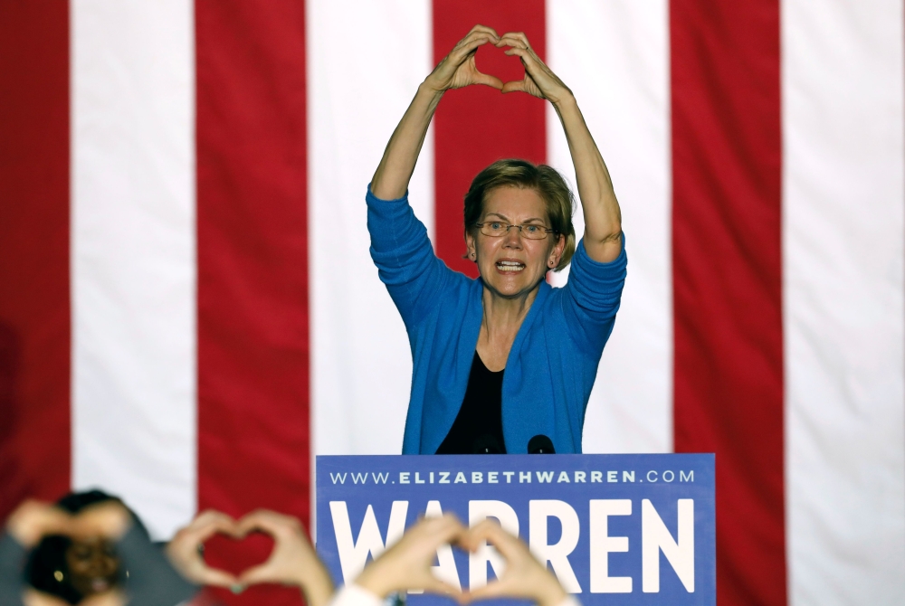 Elizabeth Warren makes the shape of a heart with her hands as she speaks during a campaign rally at Eastern Market in Detroit, Michigan, on March 3, 2020. AFP / Jeff Kowalsky
 
 