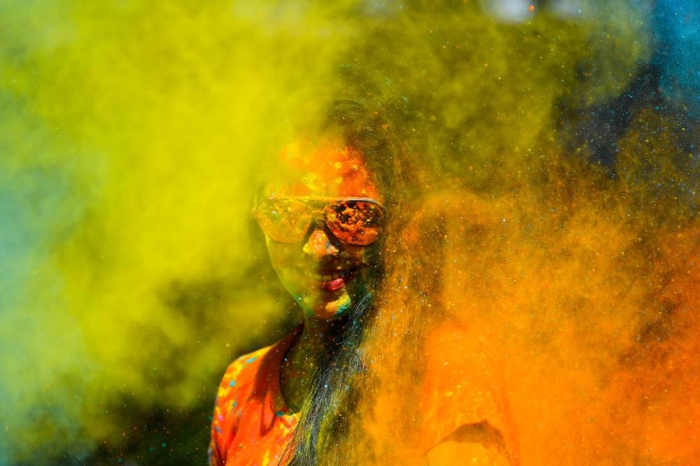 A reveller smeared in colour powder celebrates the Holi, the spring festival of colours, in Mumbai on March 10, 2020. / AFP / Indranil MUKHERJEE
