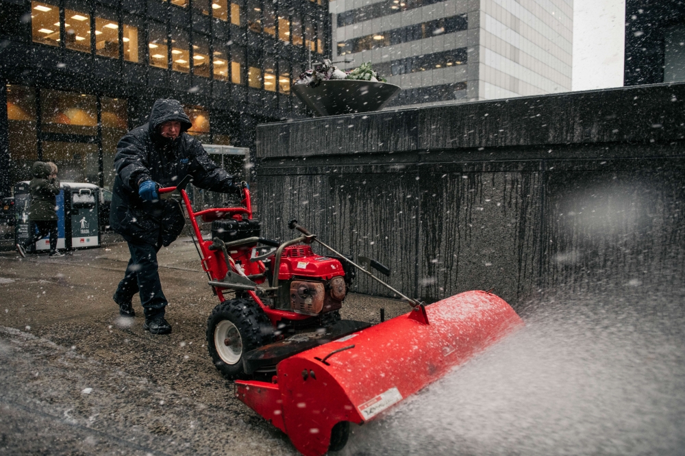 A building worker uses a snowblower to clear sidewalks in the Financial District in Manhattan, New York on December 2, 2019. Scott Heins / Getty Images / AFP