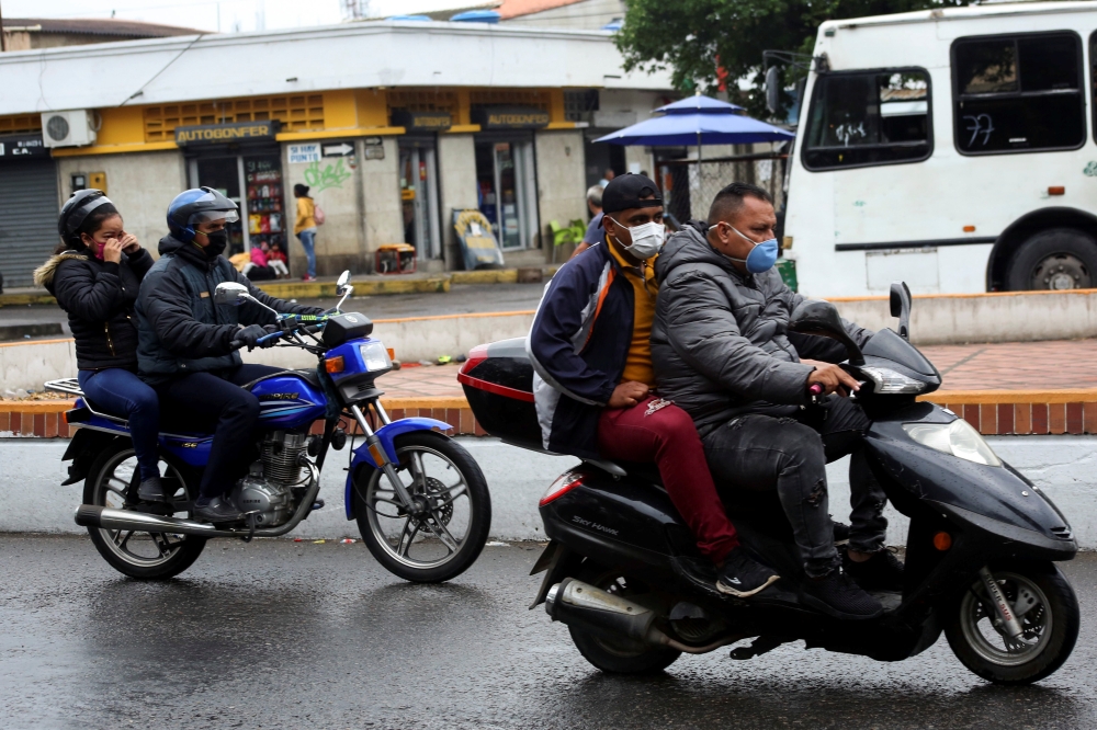  People on motorcycles wear face masks near the Venezuelan-Colombia border after the Colombian government decided to close the Simon Bolivar international bridge as a preventive measure in response to the spreading coronavirus disease (COVID-19) in San An