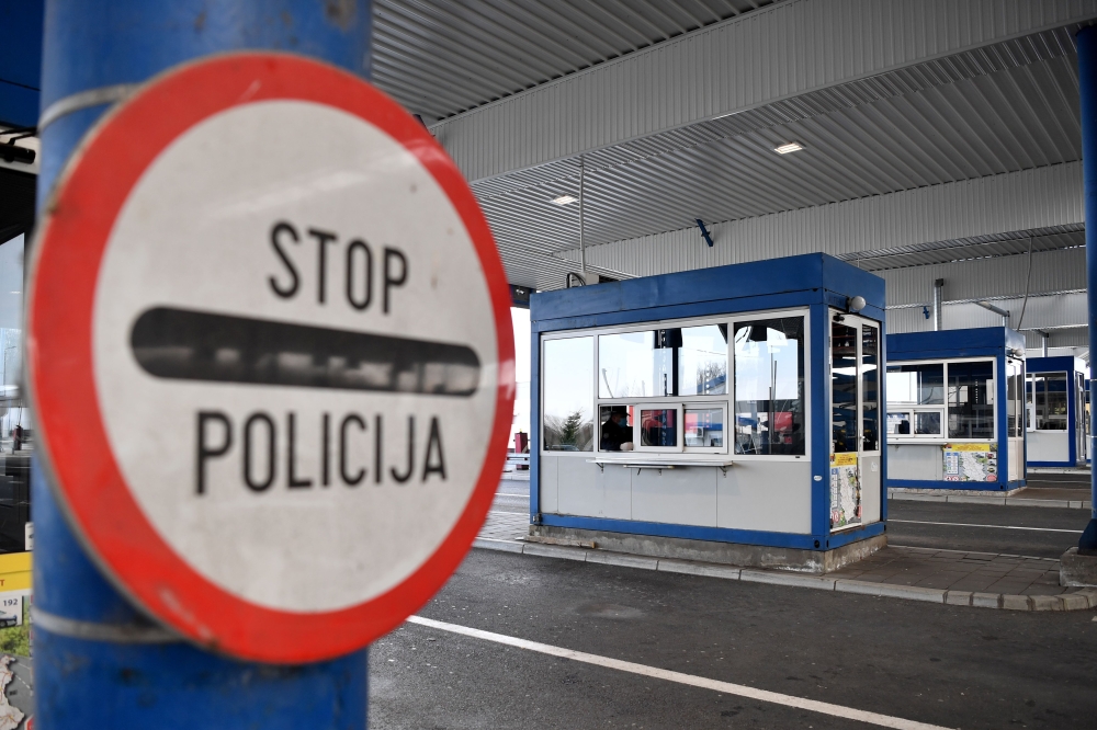Serbian border police officer wearing a protective mask waits for traveller on March 15, 2020, at the Batrovci border crossing between Serbia and Croatia. AFP / Andrej Isakovic
 
 