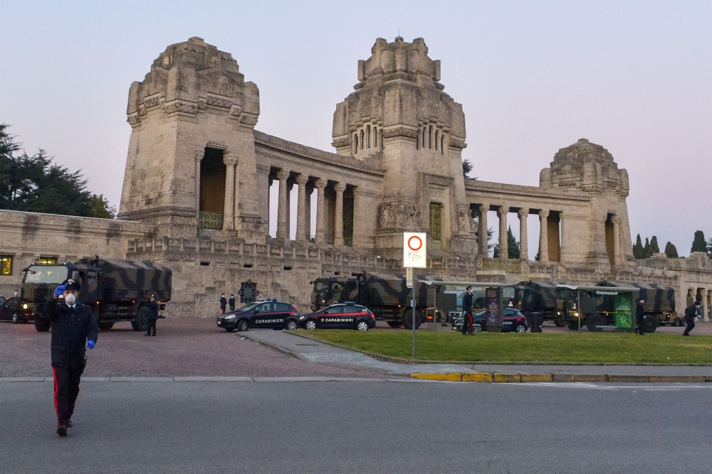 This photo provided by Italian news agency Ansa on March 19, 2020 shows Italian Army trucks parked outside the Monumental cemetery of Bergamo, Lombardy on March 18, 2020, mobilized to transport and bring about sixty coffins to crematoriums in other region