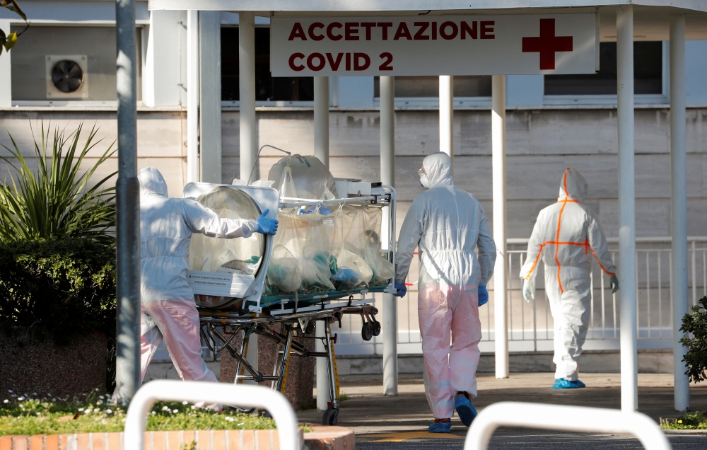 Medical workers in protective suits push an isolation stretcher in front of the Columbus Clinic, where patients suffering from coronavirus disease (COVID-19) were moved from Spallanzani Hospital, in Rome, Italy March 16, 2020. Reuters/Remo Casilli
 
 
