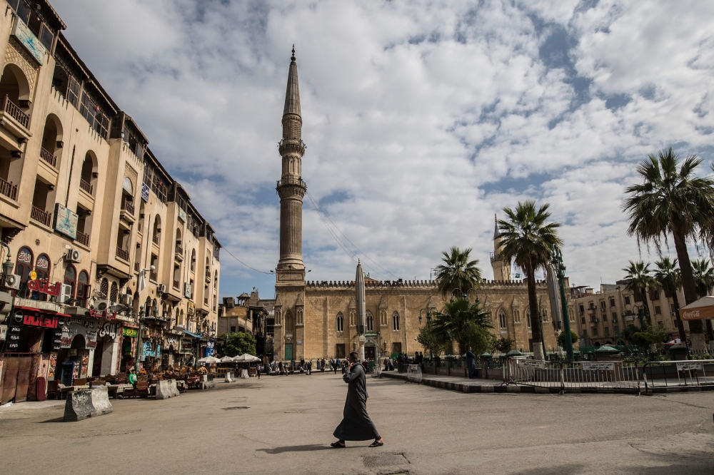 A man walks in the vicinity of the closed al-Hussein mosque in Egypt's capital Cairo on March 20, 2020, after the country's Muslim religious authorities decided to put the Friday prayers on hold, in order to avoid gatherings and the spread of the novel co