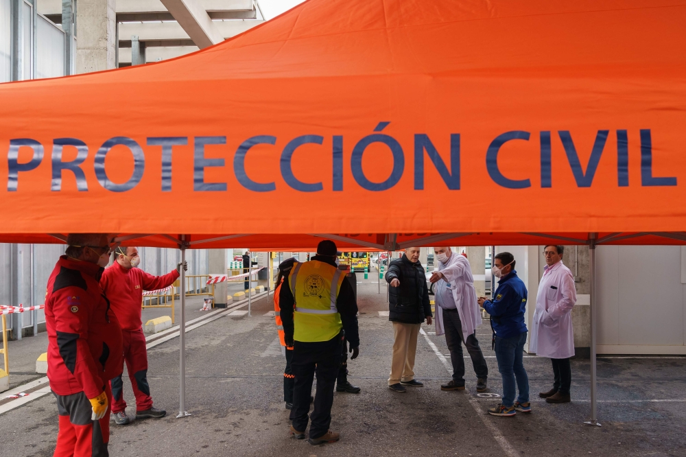 Civil Protection workers and health workers set up a triage tent for suspected coronavirus patients outside the Burgos Hospital (UBU) on March 20, 2020, in Burgos, in northern Spain. / AFP / CESAR MANSO