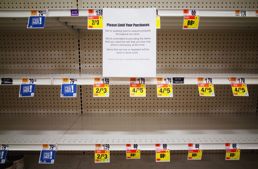 A message is posted on near empty shelves for canned goods in a supermarket in Washington, DC on March 20, 2020.  / AFP / MANDEL NGAN
