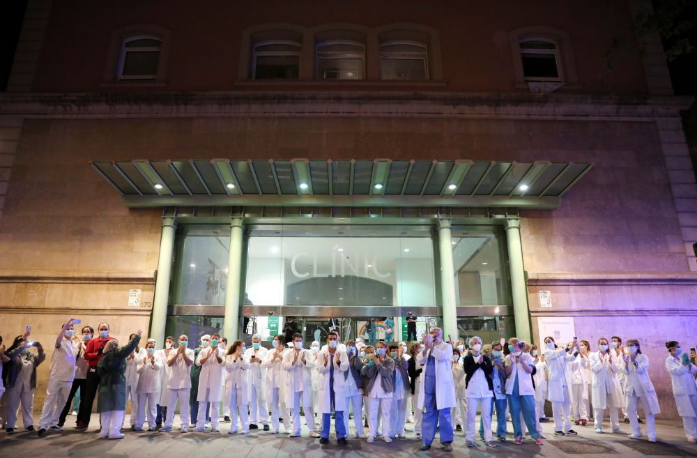 Health workers from Clinic hospital applaud citizens who show them gratitude from their balconies and windows, during the coronavirus disease (COVID-19) outbreak, in Barcelona, Spain March 24, 2020. REUTERS/Nacho Doce