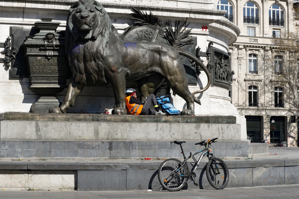 A delivery man rests in Place de la Republique during the Coronavirus lockdown in Paris, France on March 25, 2020. ( Geoffroy Van Der Hasselt - Anadolu Agency )