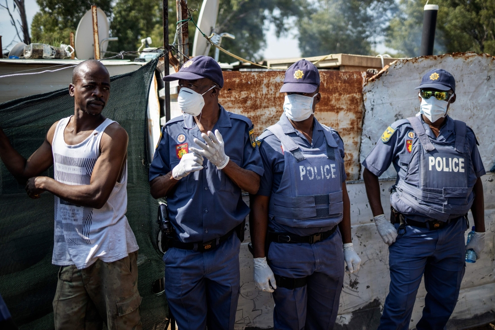 Members of the South African Police Service (SAPS) wear facemasks and gloves amid concerns over the spread of COVID-19 coronavirus in the densely populated Diepsloot township in Johannesburg, on March 21, 2020.