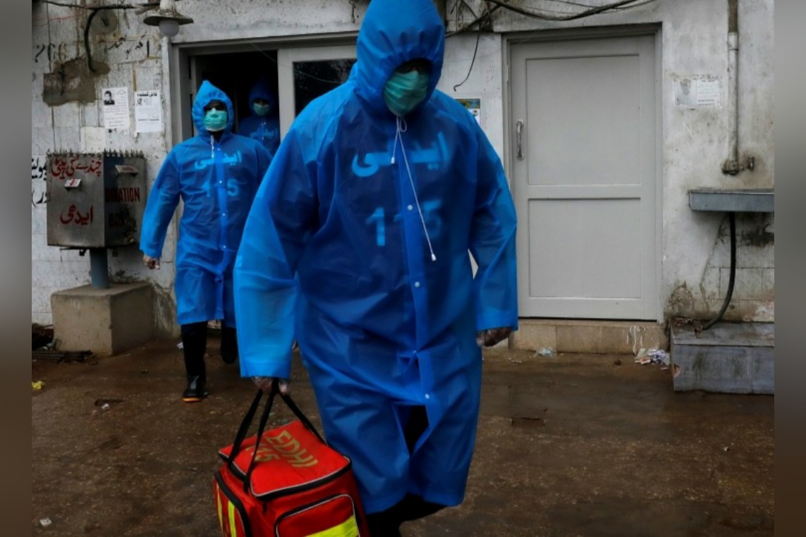 Volunteers of the Edhi Foundation, a non-profit social welfare programme, wear raincoats and boots as they pose during a mock drill on handling suspected carriers of the coronavirus disease (COVID-19), in Karachi, Pakistan March 26, 2020. REUTERS/Akhtar S