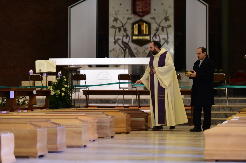 Priest Don Marcello blesses the coffins lined up in the church of San Giuseppe, waiting to be brought to the crematorium by the Italian military on March 28, 2020 in Seriate, Italy. (Pier Marco Tacca / Anadolu Agency)