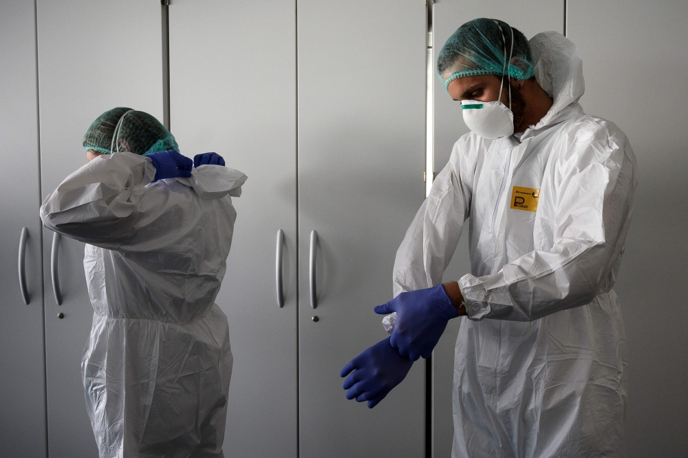 Nurses put on their Personal Protective Equipment (PPE) before starting to work on the preparation of the Intensive care unit in the new Covid-19 Hospital on March 29, 2020 in Verduno, near Alba, Northwestern Italy o AFP / MARCO BERTORELLO
