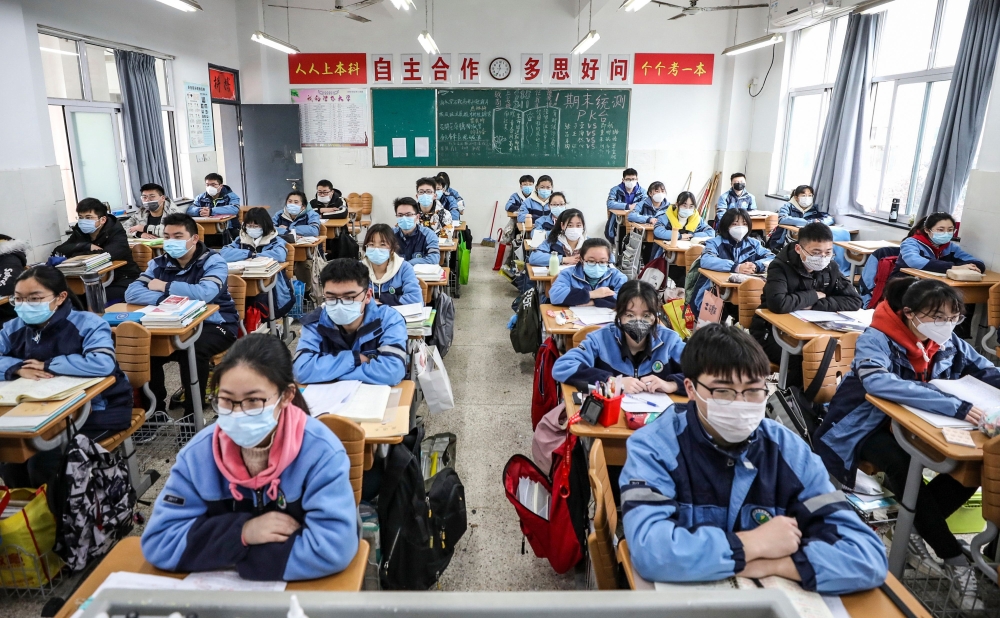 Students sit in a classroom as grade three students in middle school and high school return after the term opening was delayed due to the COVID-19 coronavirus outbreak, in Huaian in China's eastern Jiangsu province on March 30, 2020. / AFP / STR