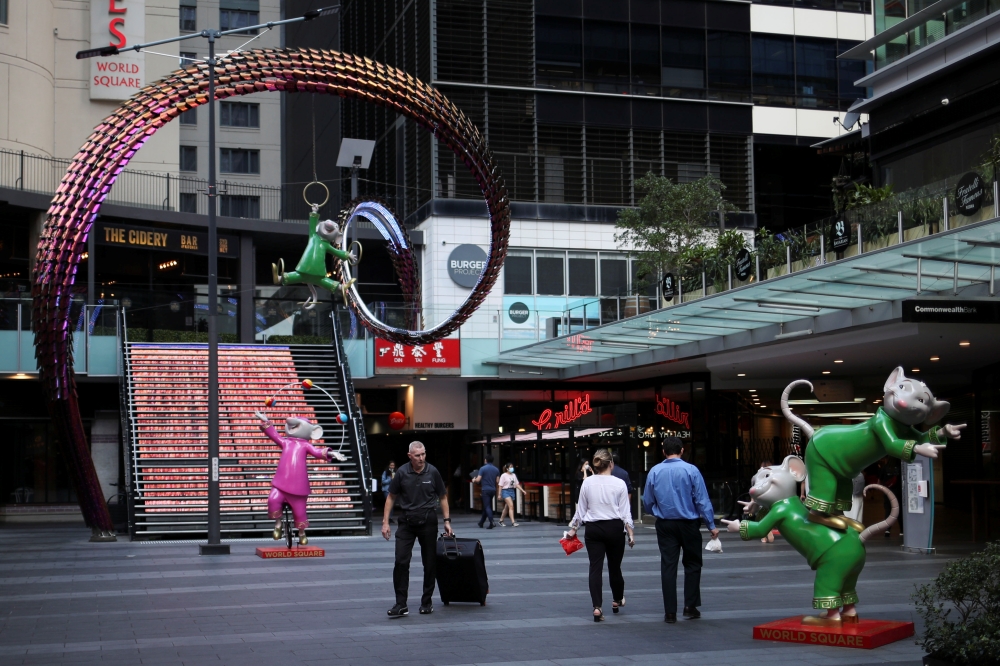 People walk by an area of the city following the implementation of stricter social-distancing and self-isolation rules to limit the spread of the coronavirus disease (COVID-19) in Sydney, Australia, March 31, 2020. REUTERS/Loren Elliott