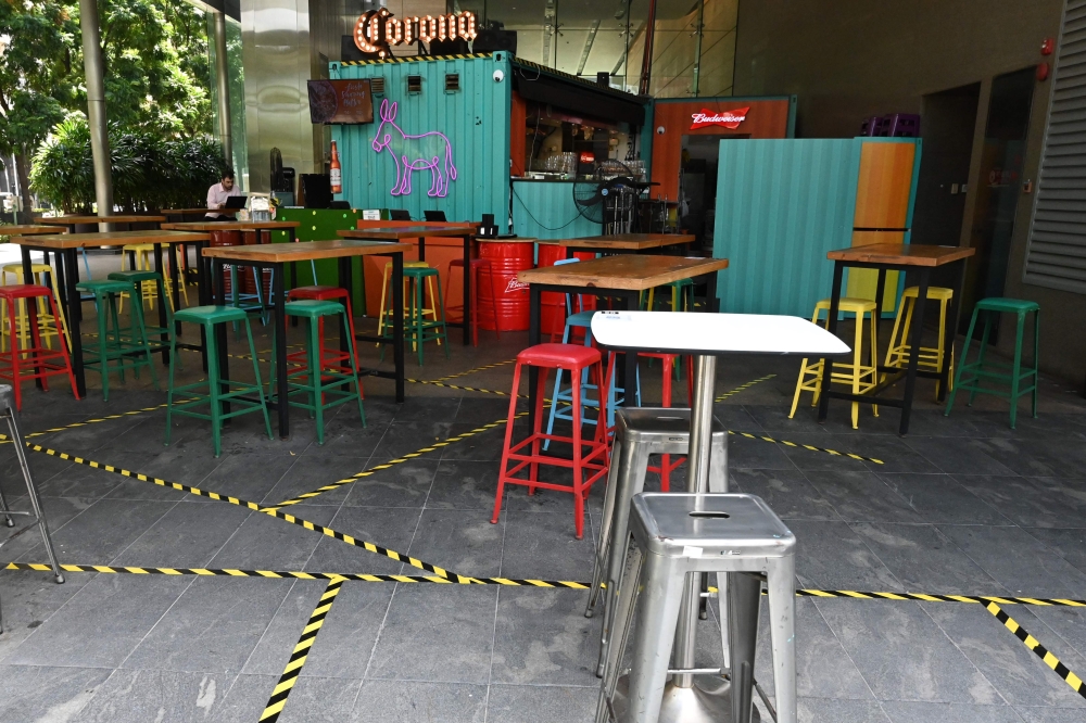 Tape to mark off spaces for social distancing are seen on the floor of a restaurant in Marina Bay in Singapore on April 2, 2020, as the government slowly tightens restrictions to combat the spread of the COVID-19 novel coronavirus. / AFP / Roslan RAHMAN