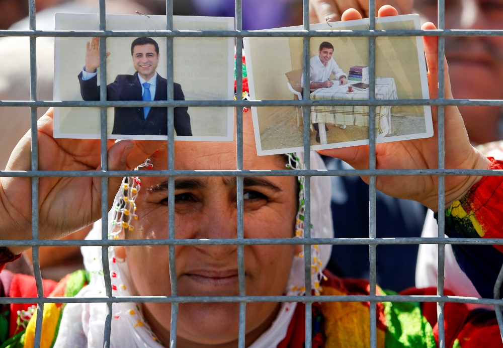 FILE PHOTO: A woman holds pictures of jailed former leader of Turkey's main pro-Kurdish Peoples' Democratic Party Selahattin Demirtas as people gather to celebrate Newroz, which marks the arrival of spring and the new year, in Istanbul, Turkey March 24, 2