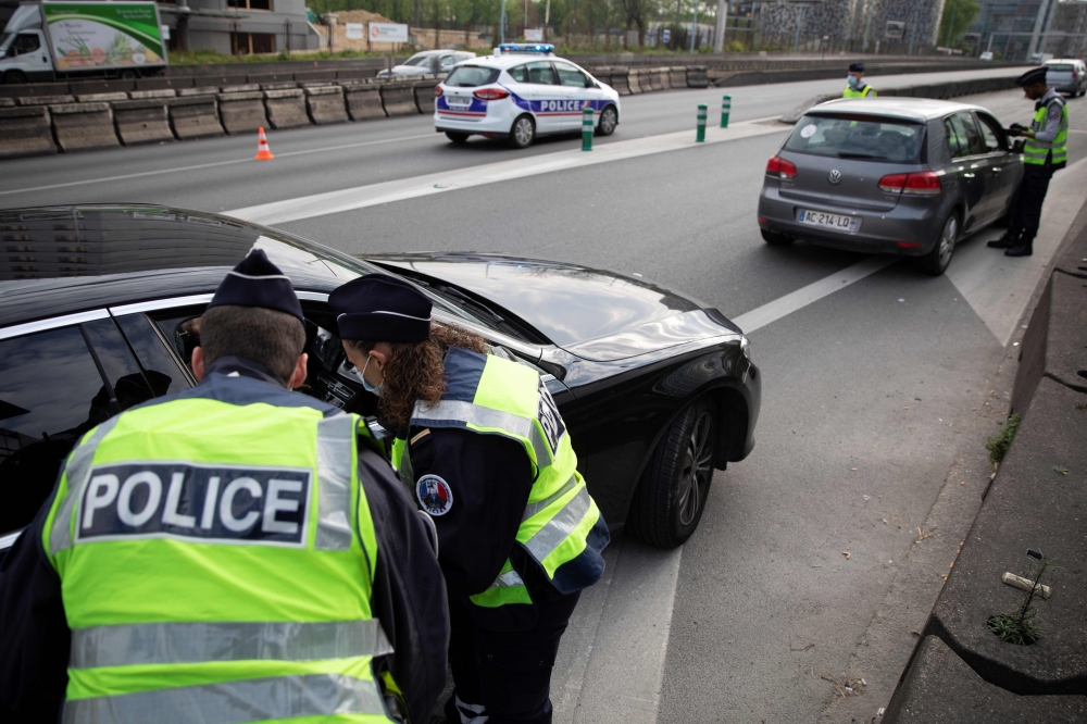 French police check motorists' outings authorisation on an access to Paris' ring-road on April 11, 2020 during the 26th day of a strict confinement in France aimed at curbing the spread of the COVID-19 disease caused by the novel coronavirus. / AFP / Thom