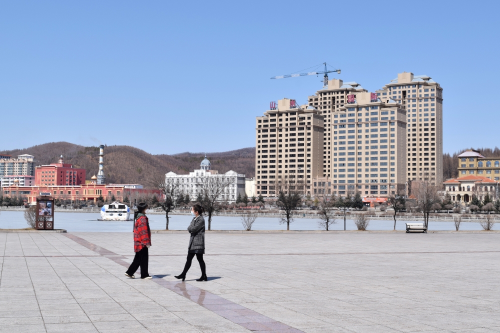 People wearing face masks are seen at a park in Suifenhe, a city of Heilongjiang province on the border with Russia, as the spread of the novel coronavirus disease (COVID-19) continues in the country, China April 12, 2020. REUTERS/Huizhong Wu