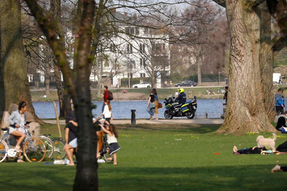 :A police motor cycle controls the area along the city Alster lake in the northern German city of Hamburg on Easter Sunday, on April 12, 2020 amid the spread of the novel coronavirus COVID-19.  / AFP / MORRIS MAC MATZEN