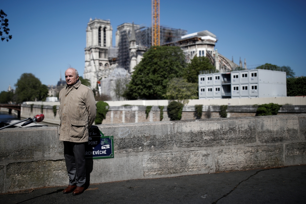 French Army General Jean-Louis Georgelin, in charge of Notre-Dame Cathedral reconstruction, stays at distance to answer journalists questions in Paris, France, April 14, 2020. REUTERS/Benoit Tessier