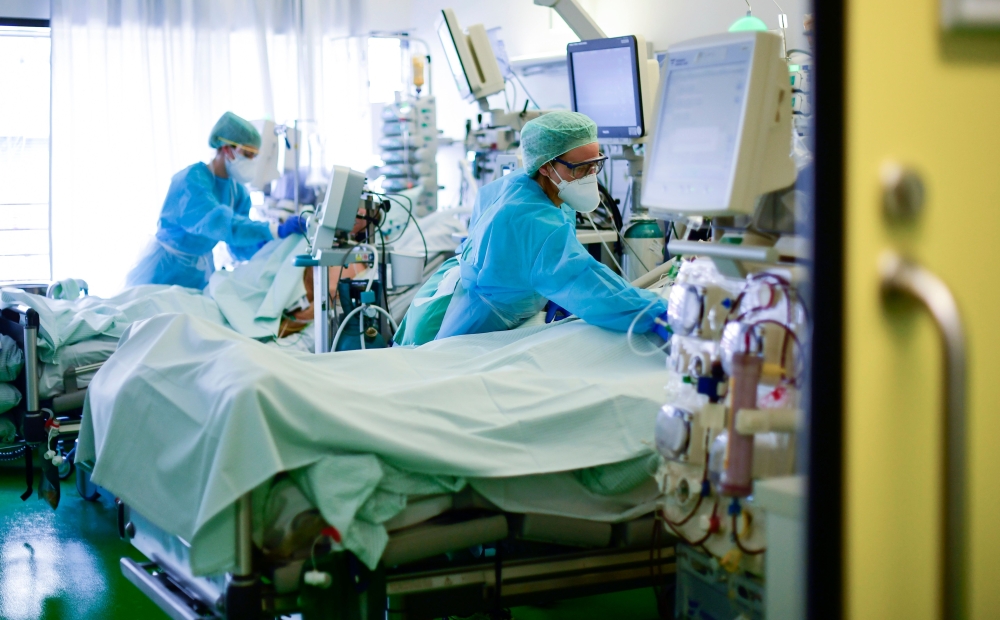 :TOPSHOT - Medical staff take care of a Covid-19 patient in an intensive care unit at the University hospital of Aachen, western Germany, on April 15, 2020 during the novel coronavirus COVID-19 pandemic. / AFP / Ina FASSBENDER