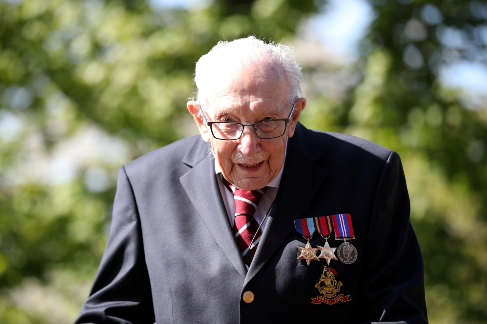 FILE PHOTO: Retired British Army Captain Tom Moore, 99, raises money for health workers by attempting to walk the length of his garden one hundred times before his 100th birthday this month as the spread of coronavirus disease (COVID-19) continues, Marsto