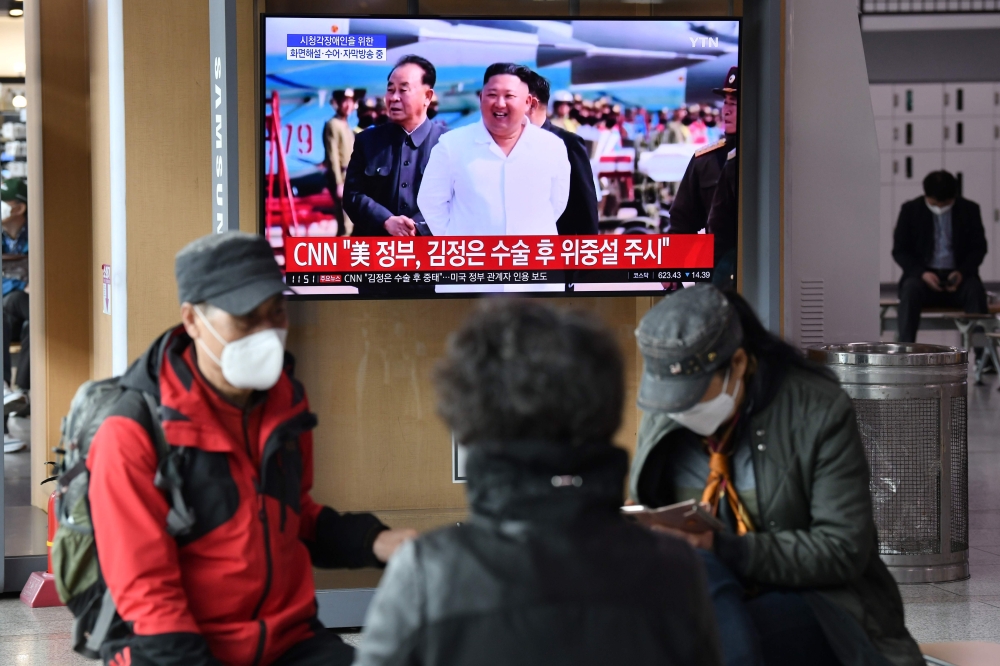 People watch a television news broadcast showing file footage of North Korean leader Kim Jong Un, at a railway station in Seoul on April 21, 2020. / AFP / Jung Yeon-je