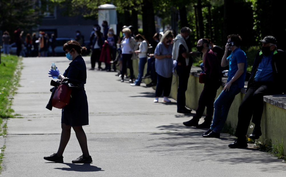 People keep social distance while waiting in line to be tested for the coronavirus disease (COVID-19) as a part of a study about undetected infections with the coronavirus in the population in Prague, Czech Republic, April 23, 2020. REUTERS/David W Cerny