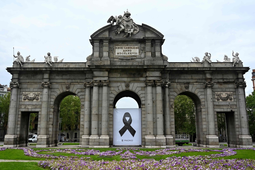 A black ribbon commemorating coronavirus victims hangs on the Puerta de Alcala in Madrid on April 23, 2020 amid a national lockdown to fight the spread of the COVID-19 coronavirus. Spain said 440 people died in the past 24 hours from the new coronavirus, 