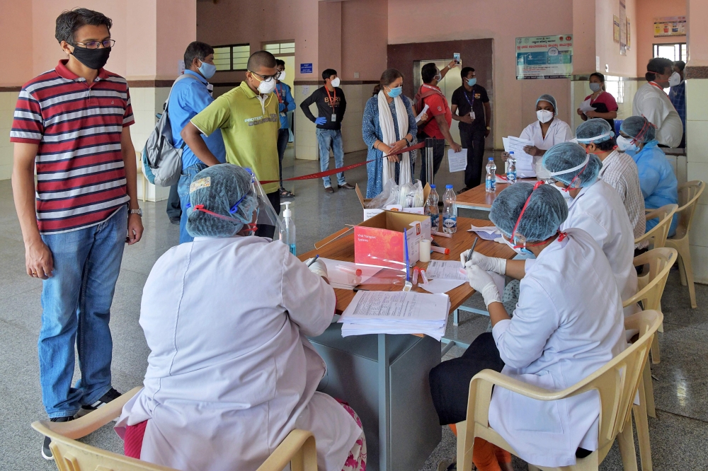 Medical professionals issue modules to members of the media before getting tested for COVID-19 coronavirus as part of an ongoing nationwide screening for media professionals during a government-imposed nationwide lockdown as a preventive measure against t