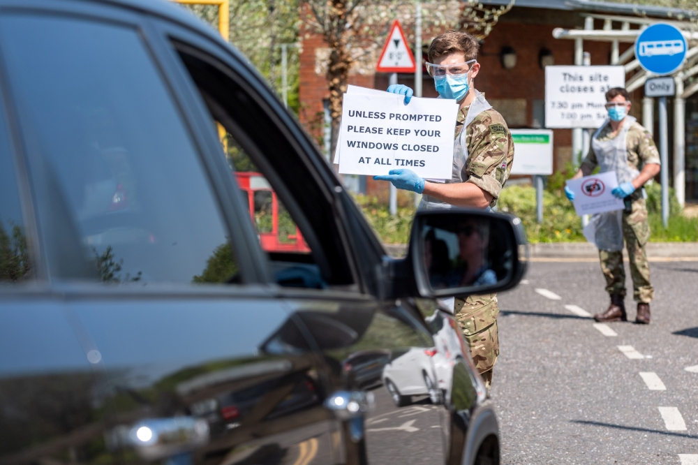 Soldiers give instructions to people in a vehicle at the mobile COVID-19 testing unit, amid the coronavirus disease (COVID-19) outbreak in Salisbury, Britain April 24, 2020. Picture taken April 24, 2020.