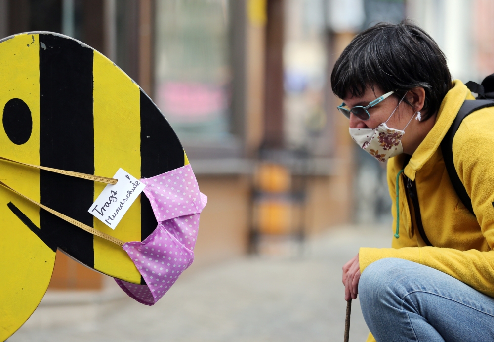A woman and a comic character are seen with a protective mask, as the spread of the coronavirus disease (COVID-19) continues in Erfurt, Germany, April 24, 2020. REUTERS/Karina Hessland