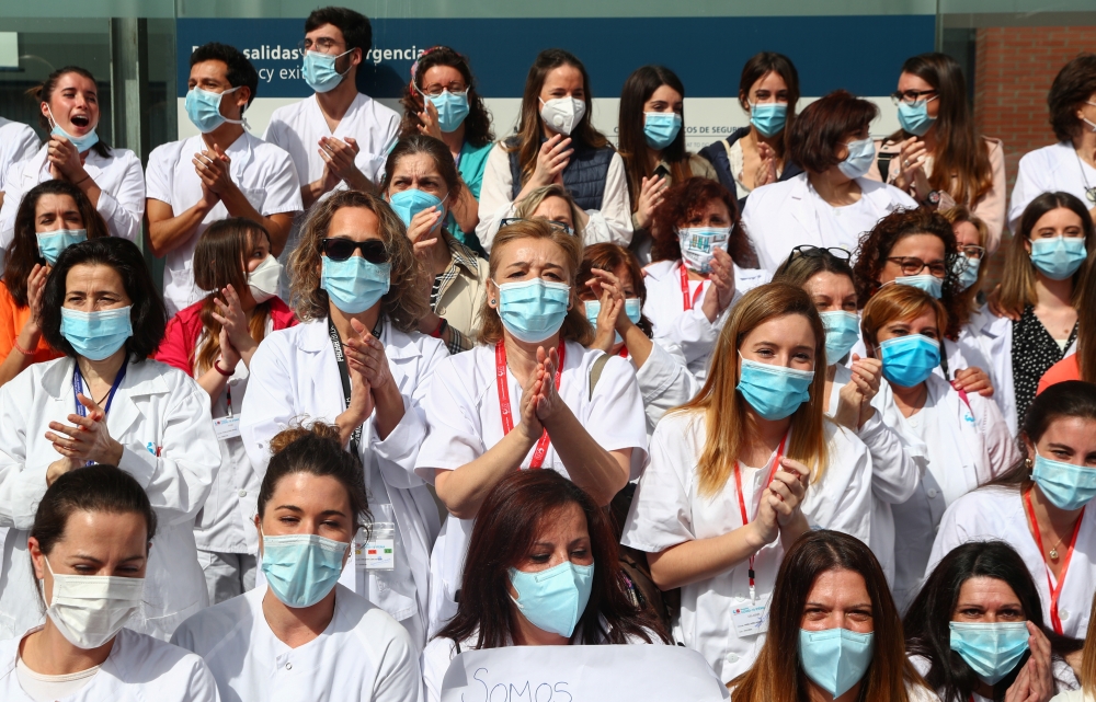 Health workers wearing protective face masks react after last patients were discharged from a temporary hospital set up at IFEMA fairgrounds, before it's closure, amid the coronavirus disease (COVID-19) outbreak in Madrid, Spain May 1, 2020. REUTERS/Sergi
