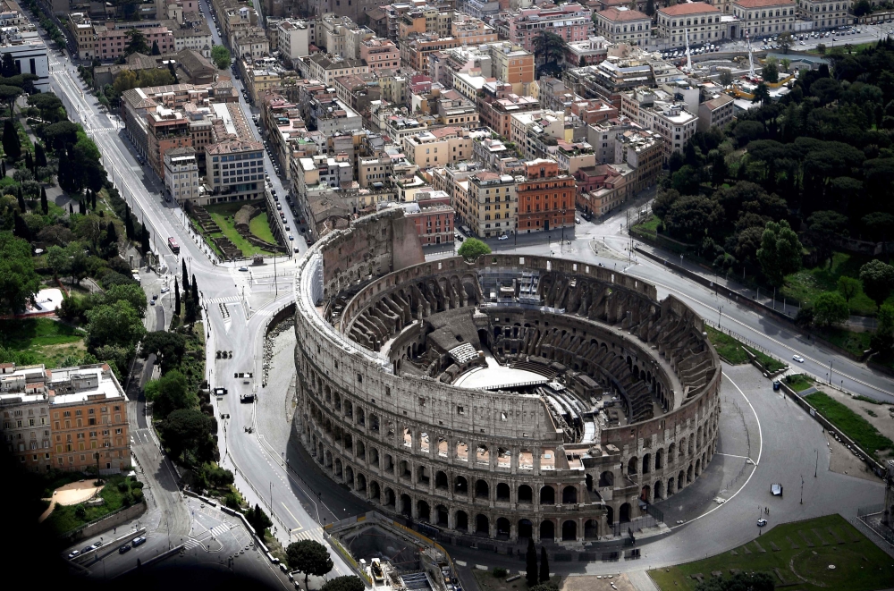 This aerial photograph taken on May 1, 2020 shows the empty streets and the Colosseum in Rome during the country's lockdown aimed at curbing the spread of the COVID-19. / AFP / Filippo MONTEFORTE
