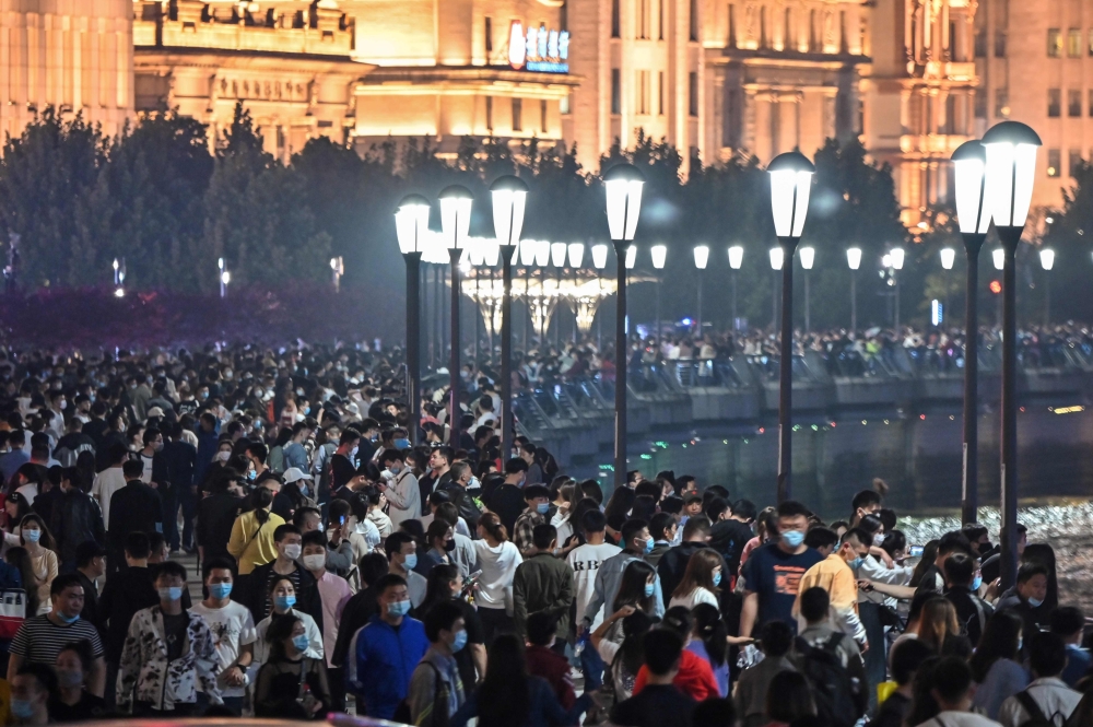 :TOPSHOT - Large crowd of people wearing face masks visit the promenade on the Bund along the Huangpu River during a holiday on May Day, or International Workers' Day, in Shanghai on May 1, 2020. With optimism and a heavy dose of caution, millions of Chin