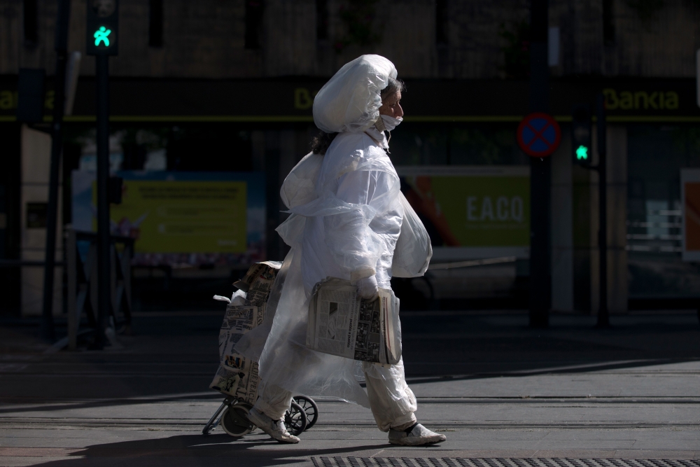 A woman covered in plastic film walks in Granada on May 2, 2020 All Spaniards are again allowed to leave their homes since today to walk or play sports after 48 days of very strict confinement to curb the coronavirus pandemic.  AFP / JORGE GUERRERO