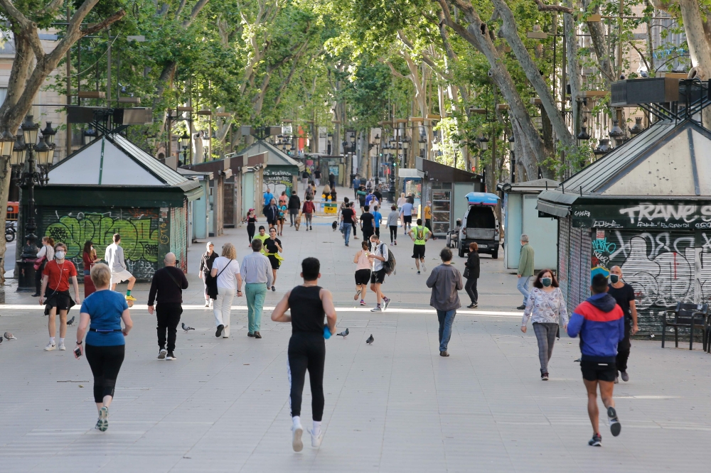 People exercise along Las Ramblas in Barcelona, on May 2, 2020, during the hours allowed by the government to exercise, for the first time since the beginning of a national lockdown to prevent the spread of the COVID-19 disease. / AFP / PAU BARRENA