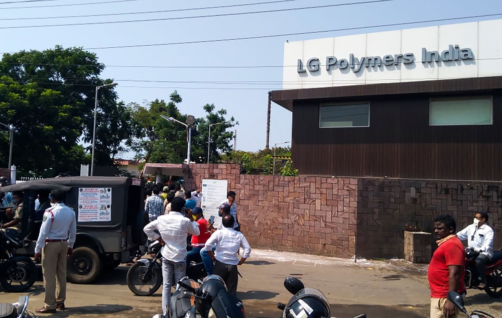 Policemen stand guard as people gather in front of a LG Polymers plant following a gas leak incident in Visakhapatnam on May 7, 2020. AFP 