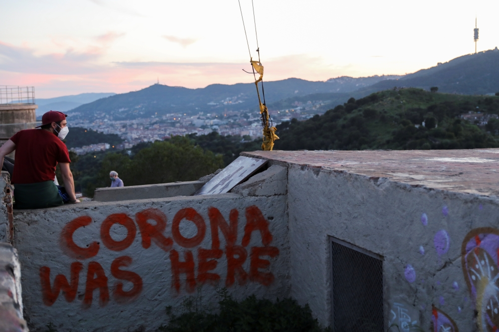 A man wears a protective face mask at a lookout point as a general view of the city of Barcelona is seen in the background, as the spread of the coronavirus disease (COVID-19) continues, in Barcelona, Spain May 6, 2020. REUTERS/Nacho Doce