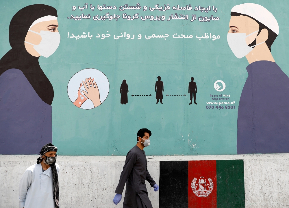 An Afghan man wearing a protective face mask walks past a painted wall during the spread of the coronavirus disease (COVID-19), in Kabul, Afghanistan May 7, 2020. REUTERS/Mohammad Ismail