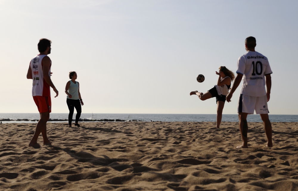 People play as they enjoy the sunny weather on the Barceloneta beach amidst the easing of restrictions implemented to curb the spread of the coronavirus disease (COVID-19), in Barcelona, Spain May 8, 2020. REUTERS/Nacho Doce