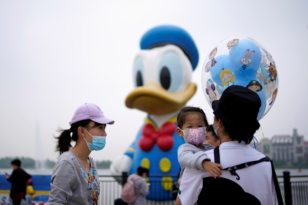 Visitors wearing face masks are seen at Shanghai Disney Resort a day before the Shanghai Disneyland theme park reopens following a shutdown due to the coronavirus disease (COVID-19) outbreak, in Shanghai, China May 10, 2020. REUTERS/Aly Song