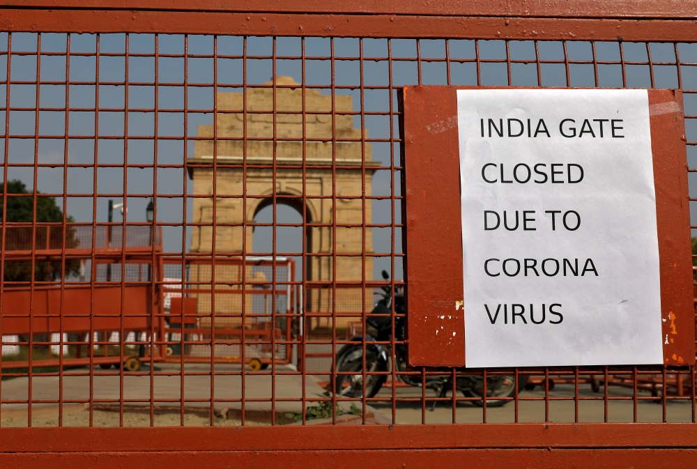 FILE PHOTO: A sign pasted on a security barricade is seen after the India Gate war memorial was closed for visitors amid measures for coronavirus prevention in New Delhi, India, March 19, 2020. REUTERS/Adnan Abidi/File Photo
