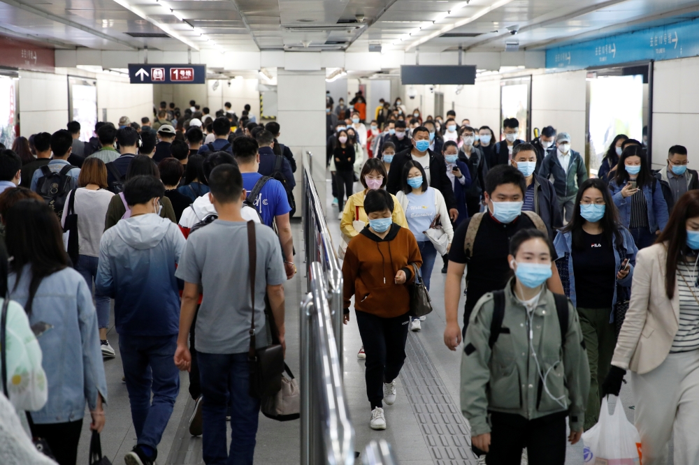 People wearing face masks walk inside a subway station during morning rush hour, following an outbreak of the coronavirus disease (COVID-19), in Beijing, China May 11, 2020. REUTERS/Carlos Garcia Rawlins