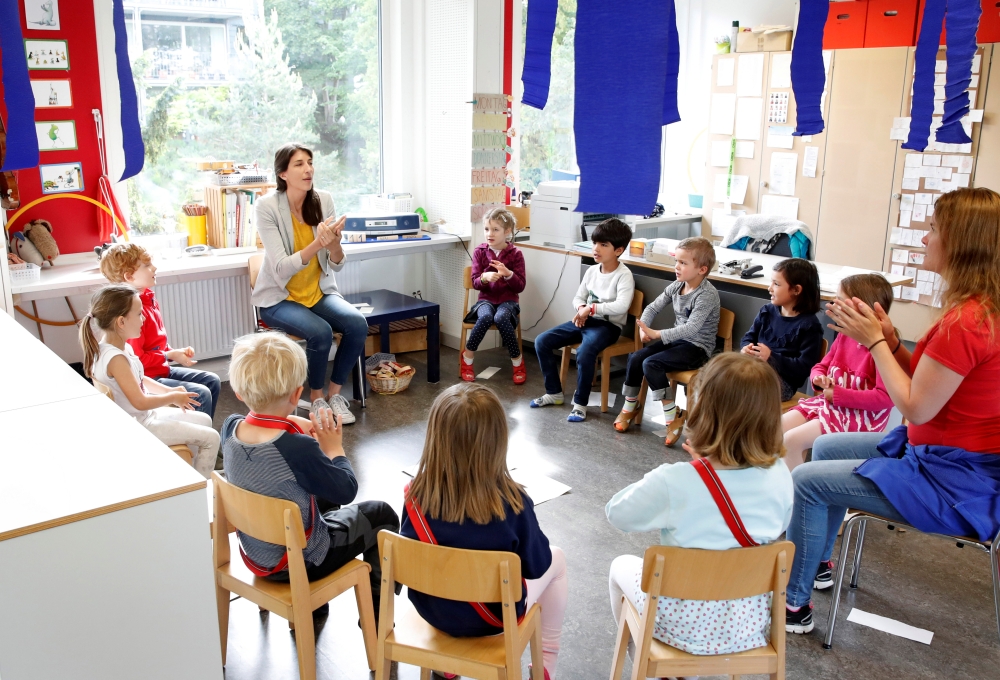 Children listen to the explanations of teacher Angela Melad on how to wash their hands at the KiGa Hutten kindergarten during the first day back as Switzerland eases the lockdown measures during the coronavirus disease (COVID-19) outbreak in Zurich, Switz