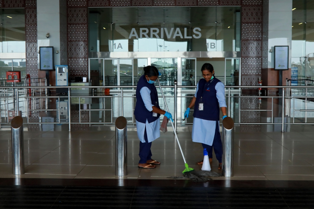 Airport staff cleans the arrivals terminal ahead of the arrival of an evacuation flight carrying Indian citizens from Gulf countries, at the Cochin International Airport in Kochi on May 6, 2020. AFP / Arunchandra Bose