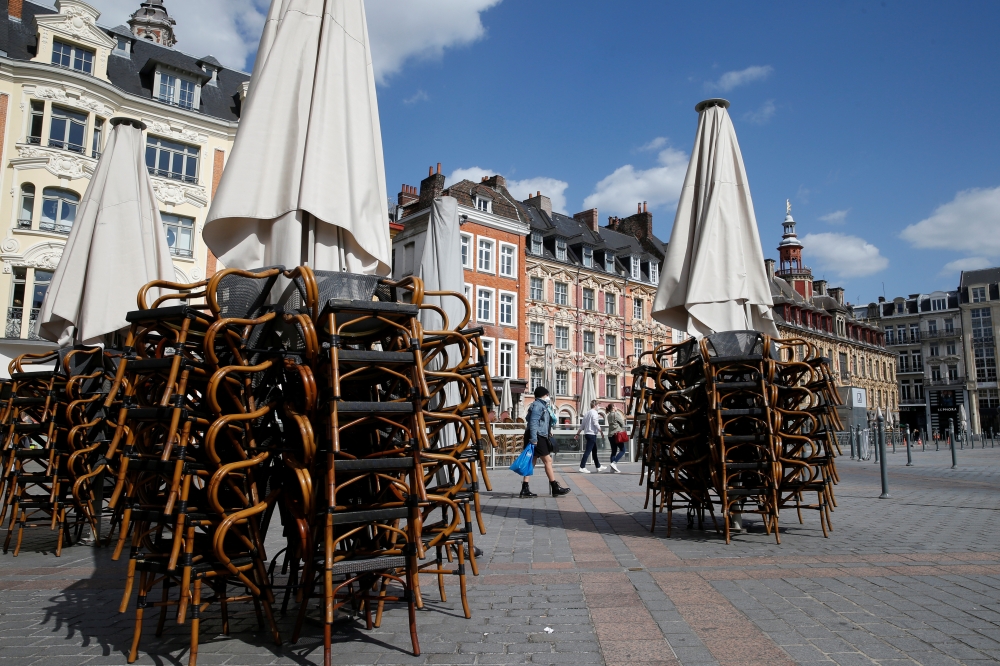 Stacked chairs are seen on the terrace of a closed restaurant at the Grand Place in Lille, after France begun a gradual end to a nationwide lockdown due to the coronavirus disease (COVID-19) in France, May 11, 2020. REUTERS/Pascal Rossignol