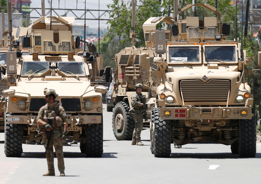 A foreign soldier keeps watch among armoured vehicles outside a hospital which came under attack in Kabul, Afghanistan May 12, 2020. REUTERS/Mohammad Ismail