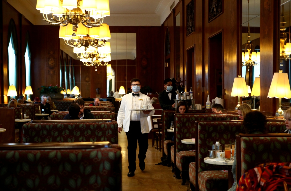 A waiter serves coffee at Cafe Landtmann during the global coronavirus disease (COVID-19) outbreak in Vienna, Austria, May 15, 2020. REUTERS/Lisi Niesner
